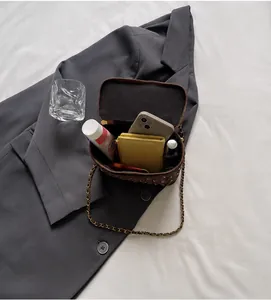 Détail montrant l'intérieur spacieux de ce sac seau matelassé marron avec chaîne