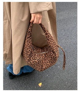 Détail d'un sac à bandoulière en daim à motif léopard avec un trench d'automne