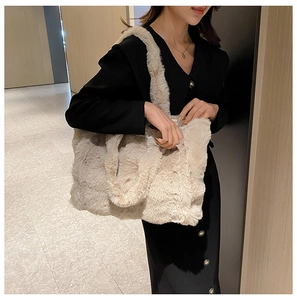 Grand sac fourre-tout en peluche beige porté par un mannequin en blazer noir