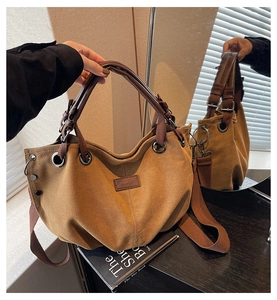 Detailed shot of retro canvas tote bag with leather handles and woven shoulder strap