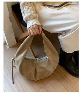 Détail du sac hobo en daim kaki avec cordon de serrage et fermeture éclair sur robe