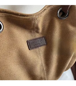 Detalle de la textura de lona con placa de cuero marrón y ojales metálicos plateados