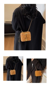 Détail d'un sac boîte matelassé marron avec chaîne dorée et perles décoratives