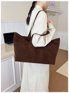 Detail of dark brown matte suede tote bag worn on shoulder for daily commute style
