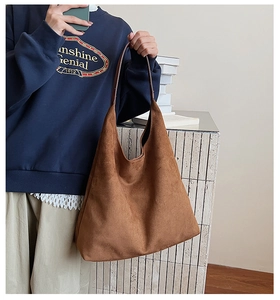 Detail of a large brown suede tote bag with soft texture for casual commuting style