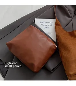 Detail of dark brown suede tote bag with matching leather inner pouch on grey suit fabric