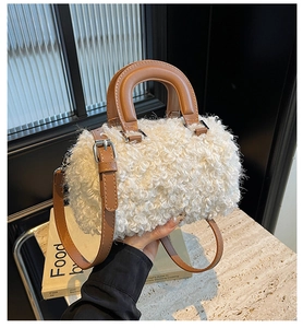 Gros plan d'un sac boîte en laine d'agneau blanche avec poignées en cuir marron et boucles