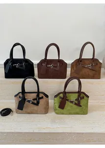 Detail of suede tote bags showing leather tags, metal buckles and detachable shoulder straps