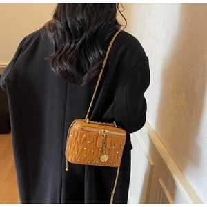 Détail du sac boîte matelassé avec cristaux et bandoulière chaîne sur le mannequin