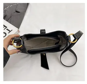 Top view of black textured leather bag with dual main compartments and gold zipper