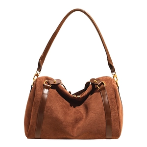 Détail du sac Boston en daim marron avec lanières en cuir lisse et finitions dorées