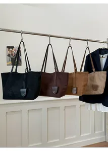 Borse shopper opache minimaliste in quattro colori appese a un supporto in stile moderno