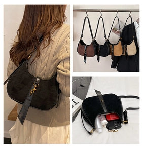 Detail view of crescent moon bag showing metallic hook clasp and suede texture