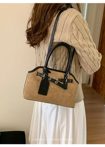 Brown faux suede shell bag with black leather handles and silver buckle details