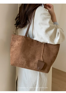 Dettaglio della grande borsa tote in pelle scamosciata marrone dallo stile rétro minimal