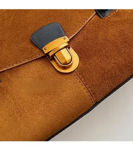 Close-up of brown suede tote bag with retro gold twist lock and fine double stitching