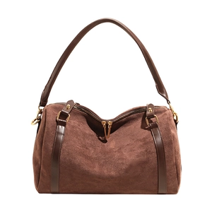 Détail du sac Boston en daim avec lanières en cuir et fermetures éclair dorées