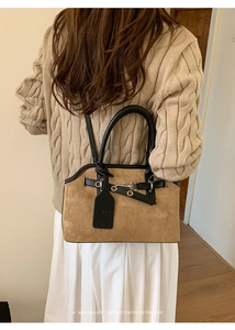 Brown suede shell bag detail with black leather trim and silver metal buckle accents