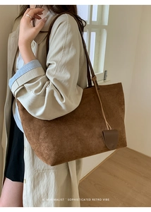 Dettaglio della borsa tote marrone in pelle scamosciata con trama retrò e nappa laterale