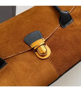 Detail of vintage brown suede Boston bag featuring metallic buckle and fine stitching