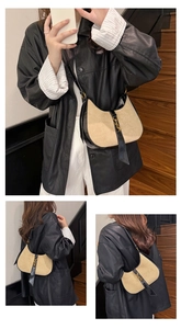 Detail of vintage beige crescent hobo bag with black leather trim and golden piston lock