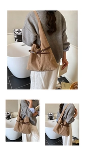 Detail of tan suede tote bag featuring a leather strap buckle and spacious vintage design