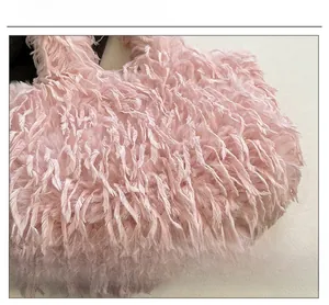 Gros plan détaillé sur la texture en plumes roses douces de ce sac cabas duveteux