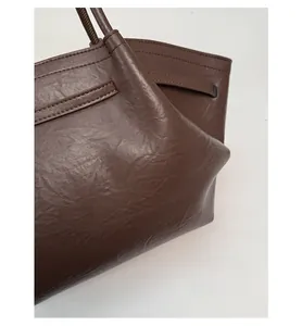 Close-up of dark brown tote bag with crinkled leather texture and durable material