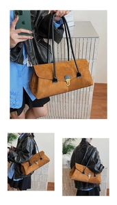 Close-up of brown suede Boston bag with long black handles and gold metallic buckle