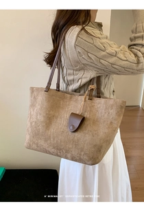 Vista dettagliata della borsa tote in pelle scamosciata marrone opaca con spalline sottili