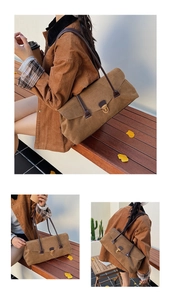 Macro detail of brown suede shoulder bag with gold metal clasp on a wooden bench