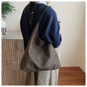 Detail of a large suede tote bag showing natural folds and soft matte texture in olive green