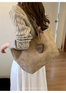 Dettaglio laterale della borsa tote in pelle scamosciata marrone con tracolla sottile