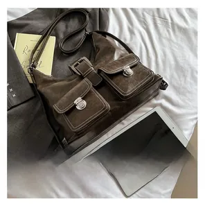 Detail of dark brown retro shoulder bag with two front pockets and silver buckles