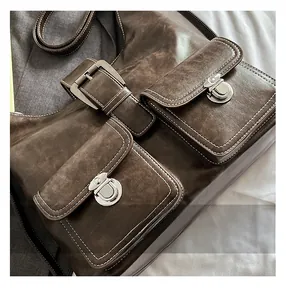 Detail of vintage brown faux leather backpack with silver turn-lock pockets and stitching