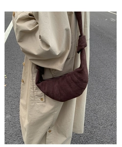 Détail montrant les coutures segmentées et la bandoulière nouée du sac croissant marron