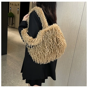 Grand sac cabas en peluche beige porté à l'épaule pour un look d'hiver élégant et douillet