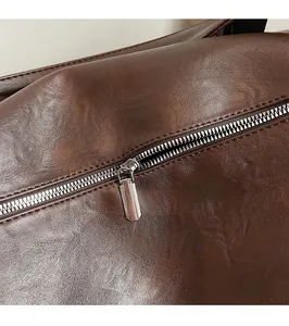 Detail of premium dark brown leather texture with polished silver metal zipper