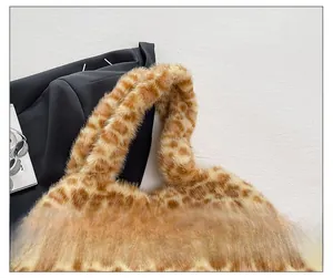 Vista dettagliata della tracolla larga di questa borsa a spalla in peluche maculato