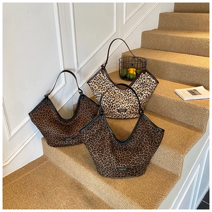 Three leopard print canvas tote bags in brown shades with V-neck design and leather straps