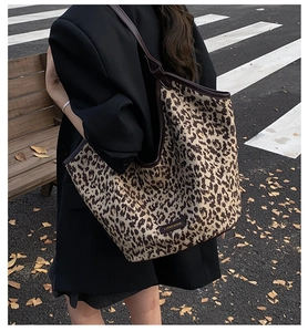 Vue détaillée du sac fourre-tout léopard à la mode porté avec un blazer d'automne noir
