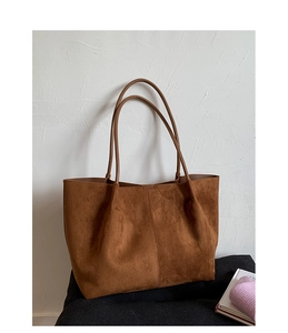 Detail view of large brown suede tote bag with slim shoulder straps for daily commute