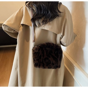 Detailansicht einer Plüsch-Beuteltasche mit Leopardenmuster und schmalem Leder-Schultergurt