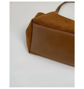 Detail of the brown tote bag featuring a reinforced wide bottom for extra storage capacity