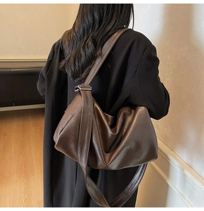 Detail view of large dark brown retro tote bag with soft pleated texture and wide strap