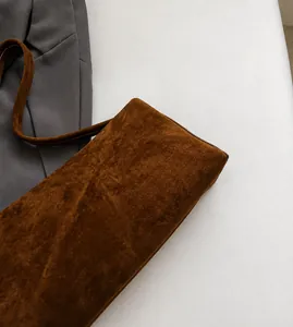 Detail van de bruine matte suède textuur op de minimalistische crossbody kussentas
