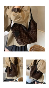 Detail of leopard print tote bag featuring black leather trim and gold logo emblem