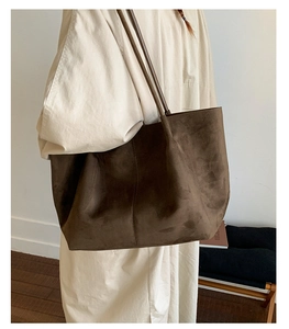 Detailed close-up showing the suede texture and stitching of the brown tote bag