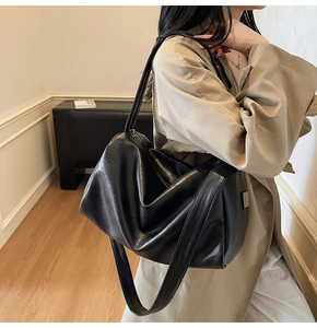 Détail du sac à bandoulière en cuir noir brillant avec des finitions métalliques