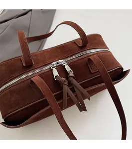 Detail shot of the dark brown matte suede pillow bag featuring smooth double zippers